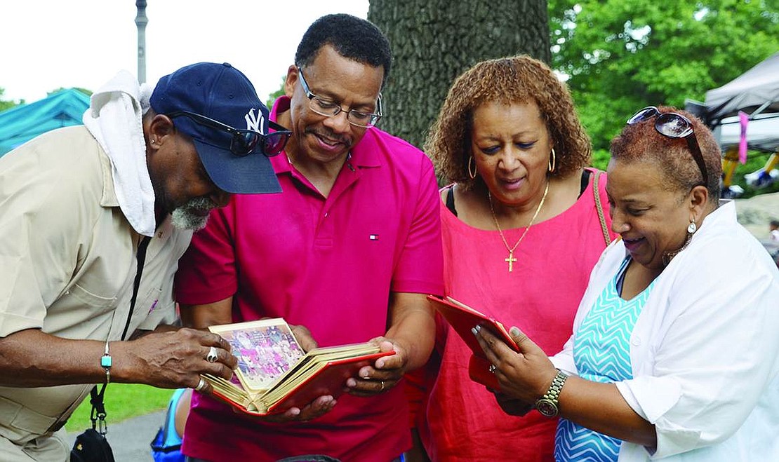  Former Port Chester residents reminisce as they look at old photos from Roosevelt Elementary School at Unity Day at Columbus Park on Saturday, Aug. 9. From left: Larry Harden, a former Purdy Avenue and South Regent Street resident who lives in South Carolina; Michael Chambless, a former South Main Street resident who lives in Rockland County; Ingraham (Branch) Taylor, a former Grove Street resident who lives in Rye; and Brenda (Coustaut) Dennis, a former Grove Street resident who lives in California.  