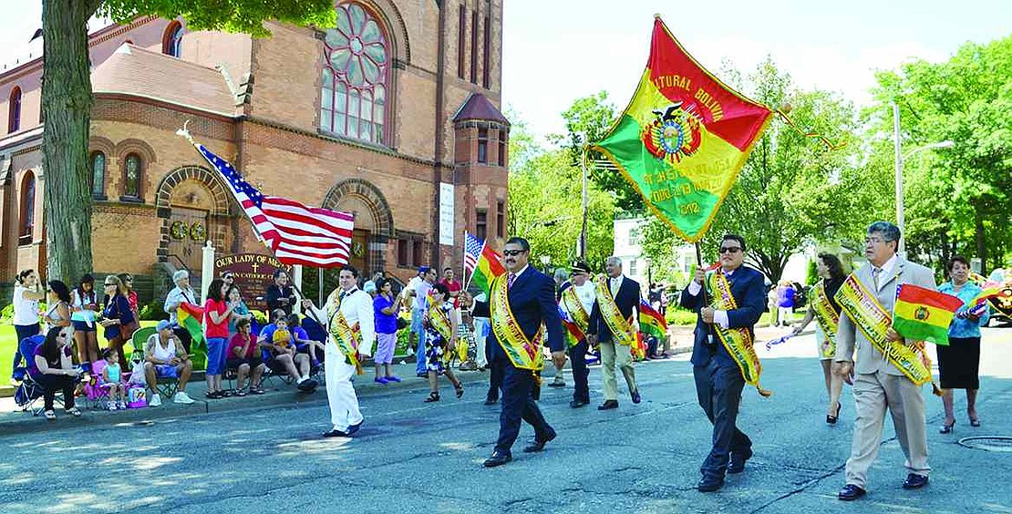 Carrying American and Bolivian flags, Modesto Maldonado (left) and Port Chester Trustee Luis Marino lead the way down Westchester Avenue followed by other local officials and a variety of cultural dance groups. 