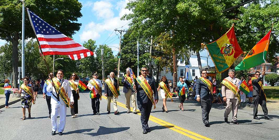 Carrying  American and Bolivian flags, Modesto Maldonado (left), Port Chester Trustee Luis Marino, Vladimir Molina, Edgar Valozuetos and Rene Iglesias lead the way down Westchester Avenue followed by other local officials and a variety of cultural dance groups. 