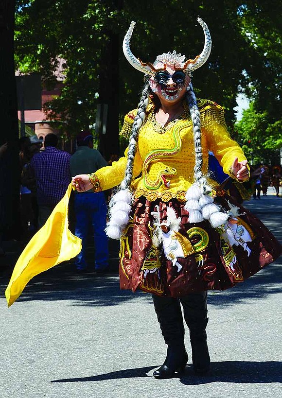Decked out in an elaborate Bolivian costume, Willma Delgado, with the Port Chester group Fraternidad La Diablada, dances down Westchester Avenue. 