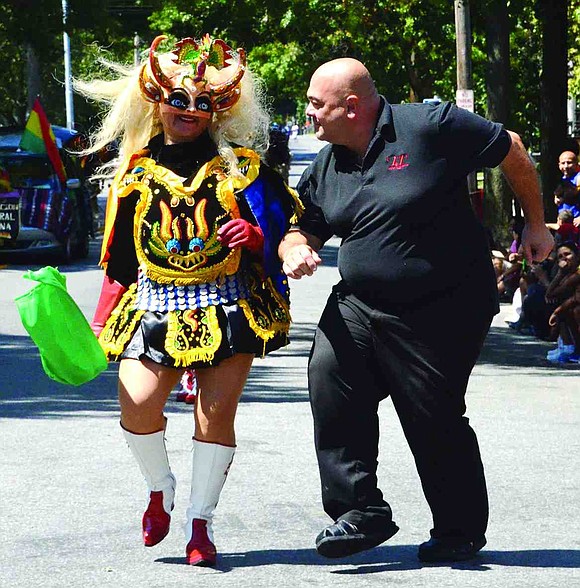 Raimondo Marrone takes a quick break from T&J Pizza and Pasta to bust a move with Carola Montaro from the Bolivian group Fraternidad La Diablada of Port Chester. Hundreds of spectators lined Westchester Avenue on Sunday, Aug. 24 to see the third annual Bolivian Parade. The entertainment continued, turning into a festival at St. Peter's Episcopal Church on Smith Street afterwards.