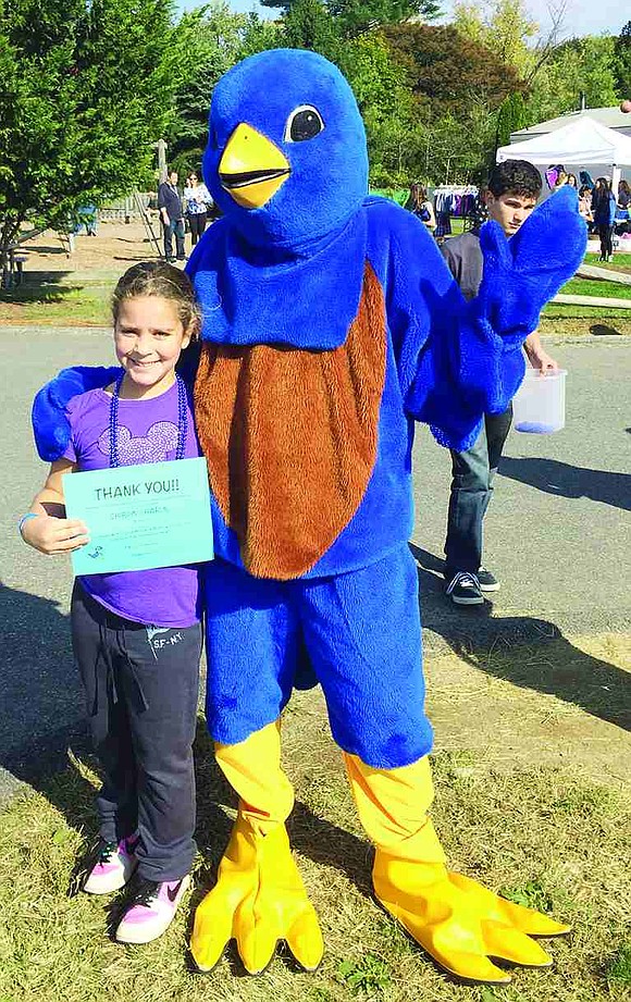 Fourth grader Anna Baker-Butler poses with the newly-named "Chirpin' Charlie," the Ridge Street School mascot. Students suggested names for the bluebird and after a school-wide vote, the students selected Baker-Butler's suggestion on "Chirpin' Charlie" as the winner. 