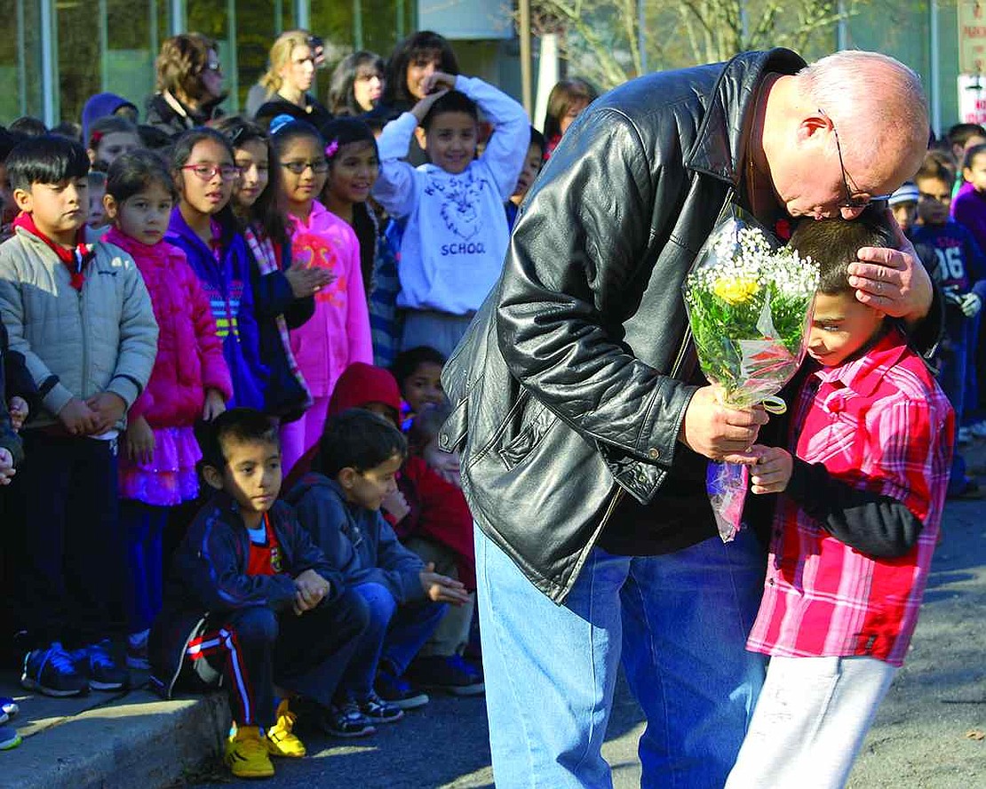  King Street School 2nd grader Lucas Faraci gets a kiss on the head from veteran Nicholas Gaglia after presenting him with a yellow rose on Monday, Nov. 10, the day before Veterans Day 