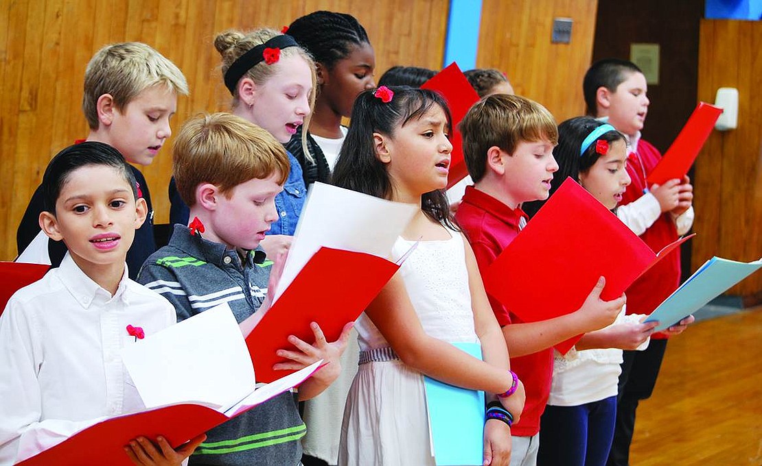  King Street School chorus members sing patriotic songs at the breakfast for veterans, students and staff inside the school following the ceremony.