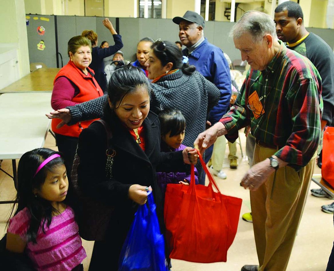  Veronica Lopez of Irving Avenue, accompanied by her children Leanny Cortez-Lopez, 7, and Andira Cortez-Lopez, 8, picks up a turkey and other Thanksgiving fixings such as vegetables, rice, lentils, raisins and dried cherries from Allen Clark of Rye at St. Peter's Episcopal Church in Port Chester on Tuesday, Nov. 25. Clark and other members of Christ Church in Rye as well as Rabbi Jaymee Alpert of Congregation KTI in Port Chester passed out 240 turkeys and fixings to needy Port Chester families.