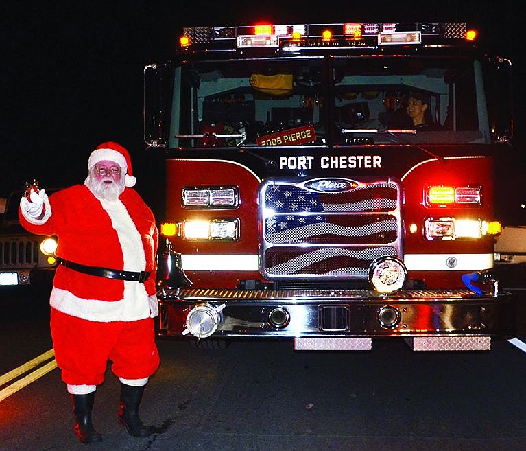 After catching a ride on a Port Chester fire truck, Santa, played by George Vigue of New Rochelle, waves at the crowd gathered to see him at Lyon Park on Thursday, Dec. 11 for the annual Santa in the Park event organized by the Port Chester Recreation Department. 