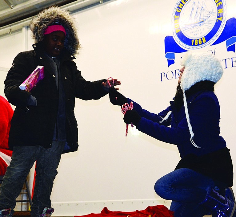 Acting as Santa's helper, Melissa Castillo hands a candy cane to Skyla Oliver, 9, of Weber Drive. 