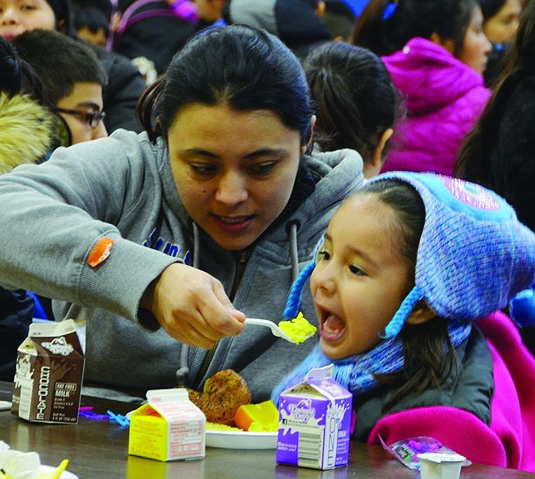 Lorena Alvear of Irving Avenue feeds some scrambled eggs to 4-year-old Julieta Martinez. 