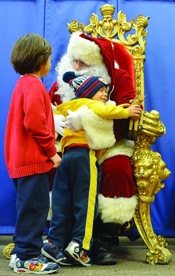 Jayden Reges of South Regent Street hugs Santa as Jayson Reges waits his turn.