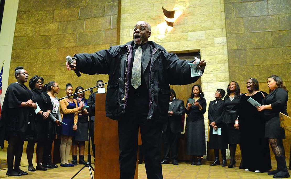 Backed up by the Girtman Memorial Choir, Joseph Mosely lifts up his voice-and his arms-while singing "We Shall Overcome." Hundreds gathered at Congregation KTI on King Street on Sunday evening, Jan. 11 for the annual interfaith service honoring the Rev. Dr. Martin Luther King, Jr.'s legacy. 