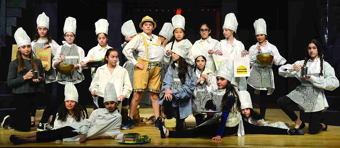  Surrounded by his many cooks, chefs and caterers, Augustus Gloop, played by 6th grader Sam Knee, proves he could easily consume a lifetime supply of chocolate. 