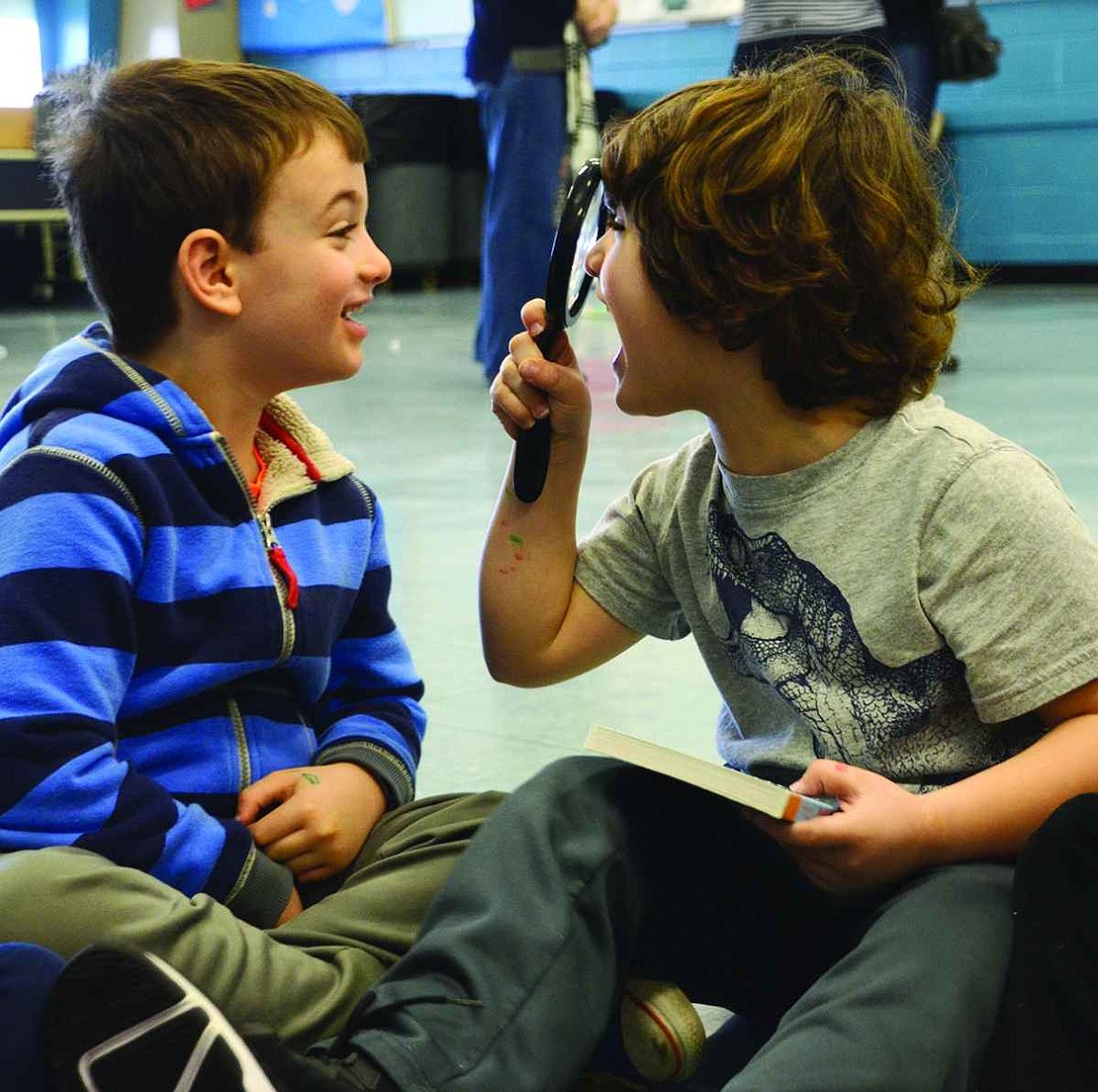  After seeing how big letters get in a book, Charlie Sindell (left) and Michael DiPaola have some fun with a magnifying glass. 