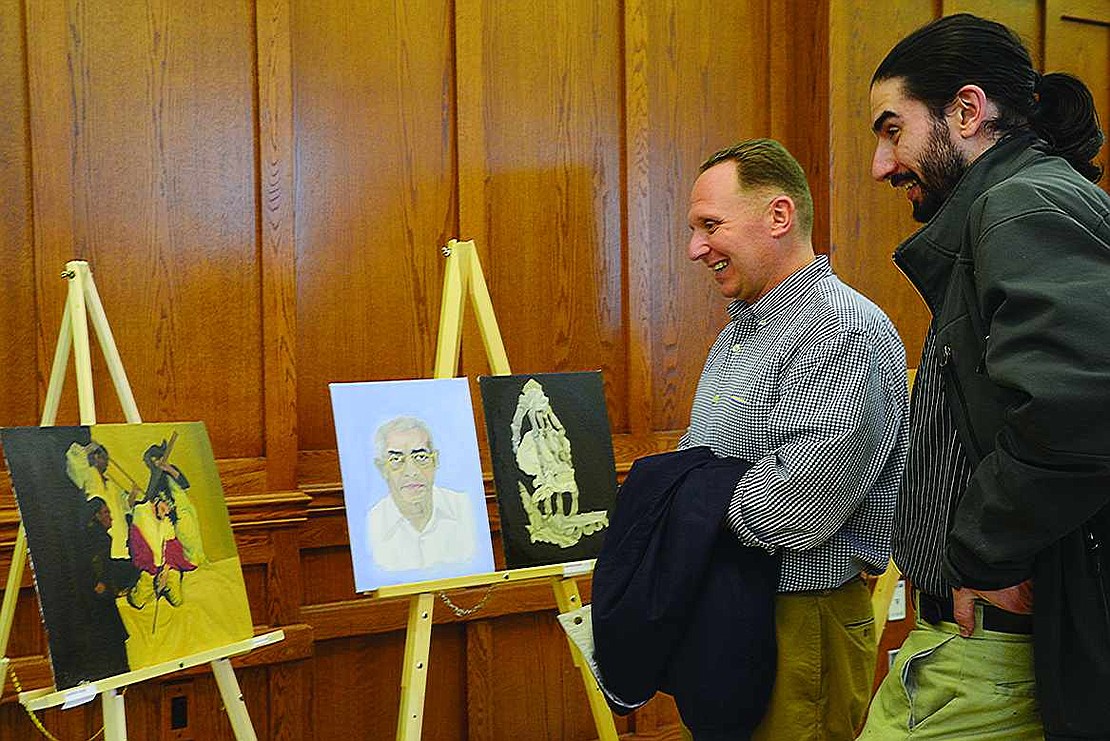  Port Chester High School instructors Mike Mouracade (left), who teaches history and art history, and James Stamboni, who teaches studio art and drawing and painting, check out the work of Augustine Joseph.