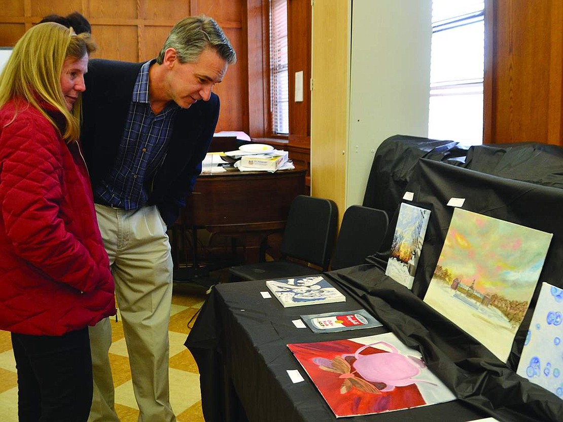  Jenny and Tom Manos look at the artwork created by some of their daughter Emma's fellow students.