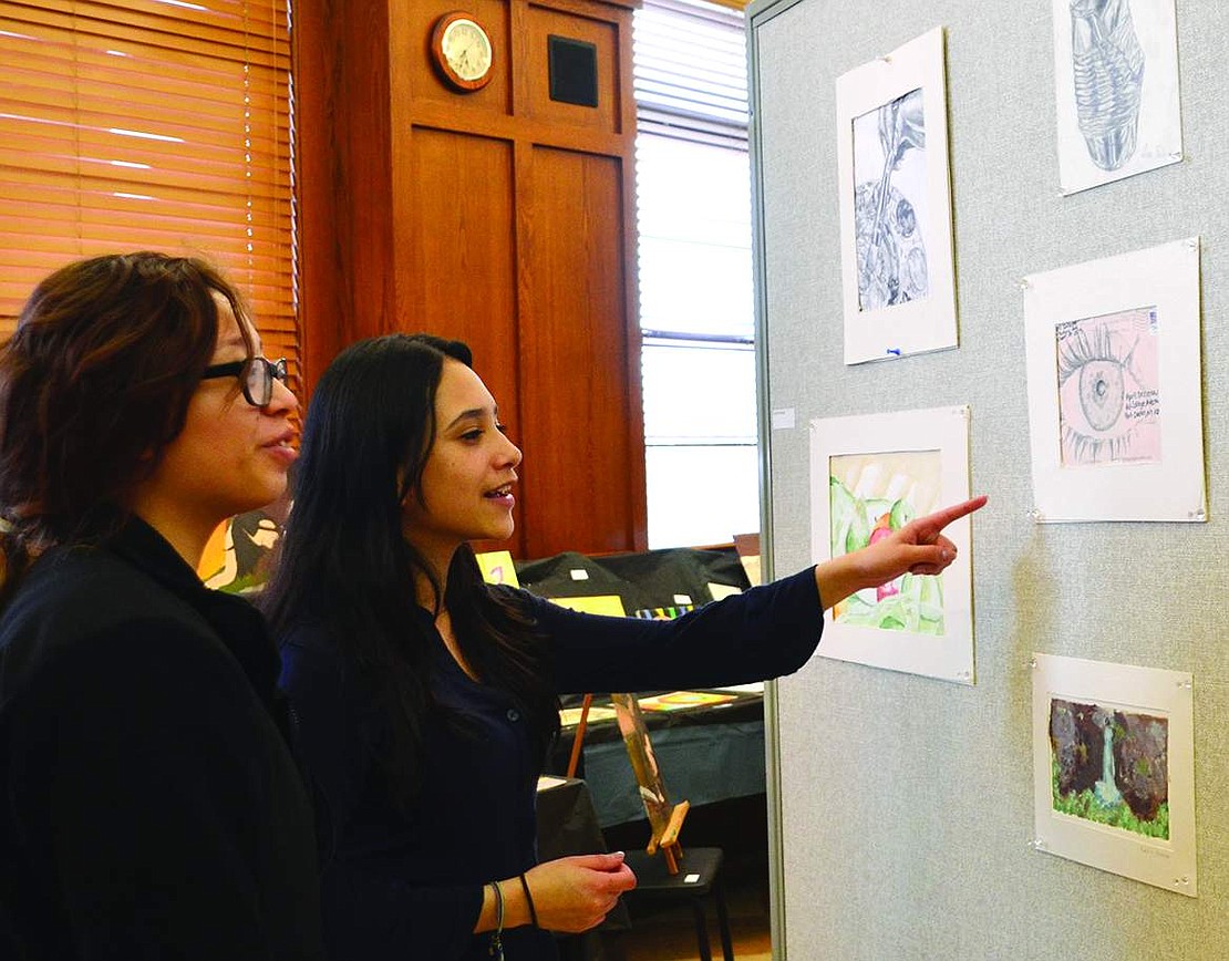  Leslie Salcedo points out a drawing she did to her friend Jessica Bonilla.