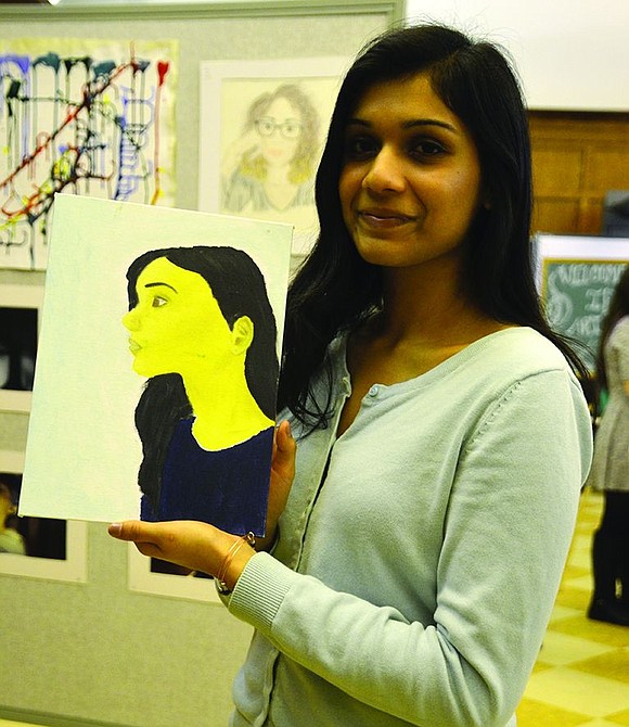  Ruhi Mathew holds up a semi-self-portrait which also includes elements of her younger sister. 