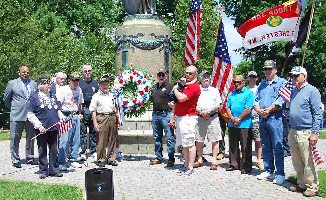 All of the veterans who attended the ceremony gather in front of the central monument at Veterans' Memorial Park. 