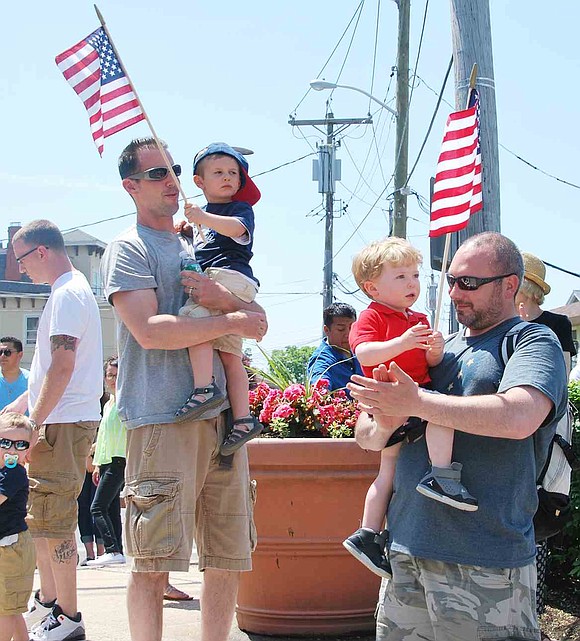 Two Port Chester dads hold their two-year-old sons as they wave American flags during the ceremony. From left: Mark and Ryan Gryzlo of Westchester Avenue and Carter and Bryan Smith of Munson Street. 