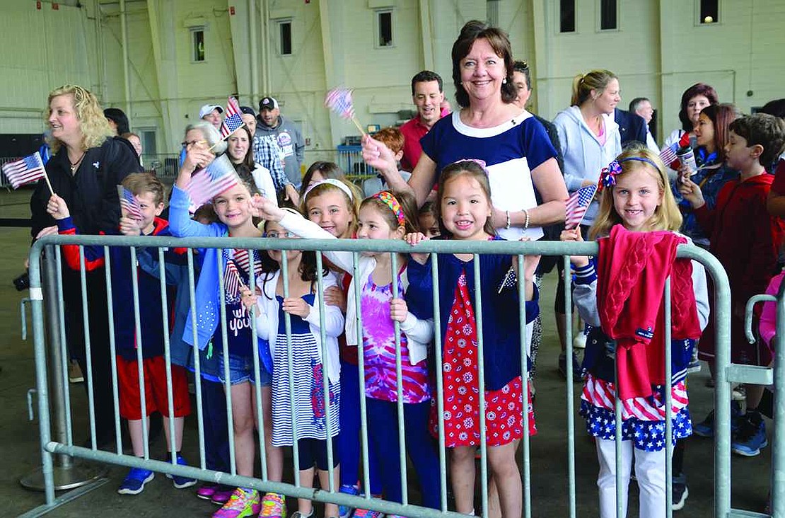  Ridge Street School first graders from Linda Greco's class wave flags. The students in Greco's class made books to be presented to each veteran who went on the flight, including Maddie Fishbach's great-grandfather. 