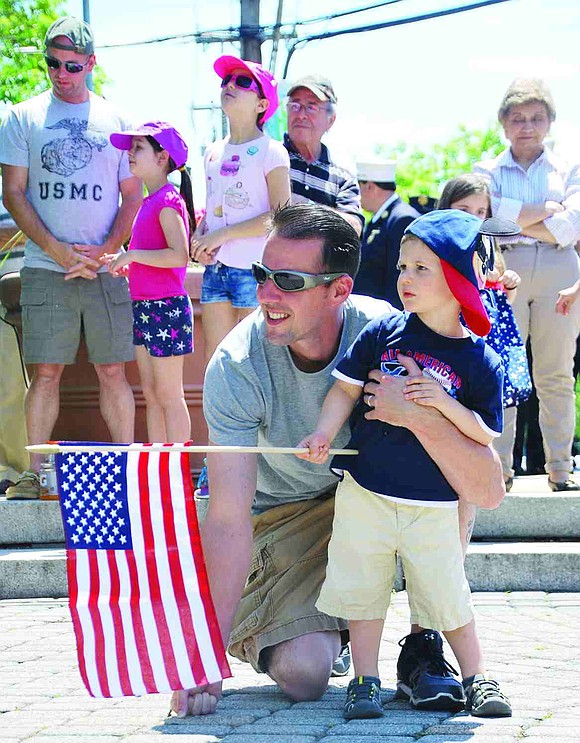 Mark Gryzlo of Westchester Avenue and his two-year-old son Ryan listen to the patriotic tunes played by the Port Chester American Legion Band at Veterans' Memorial Park on Monday, May 25. 