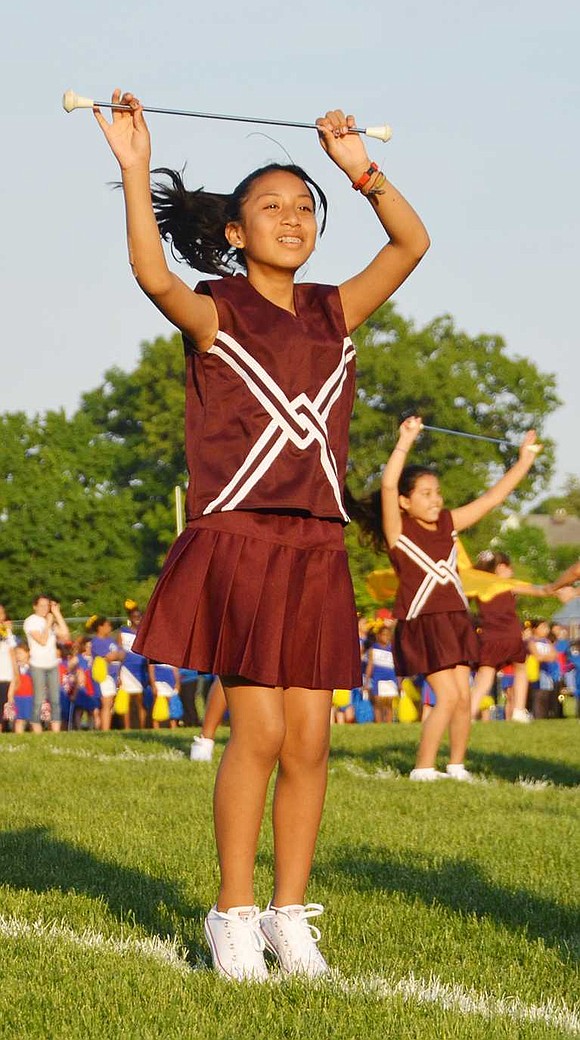 Jennifer Chabla, a 5th grader at King Street School, raises her baton over her head.