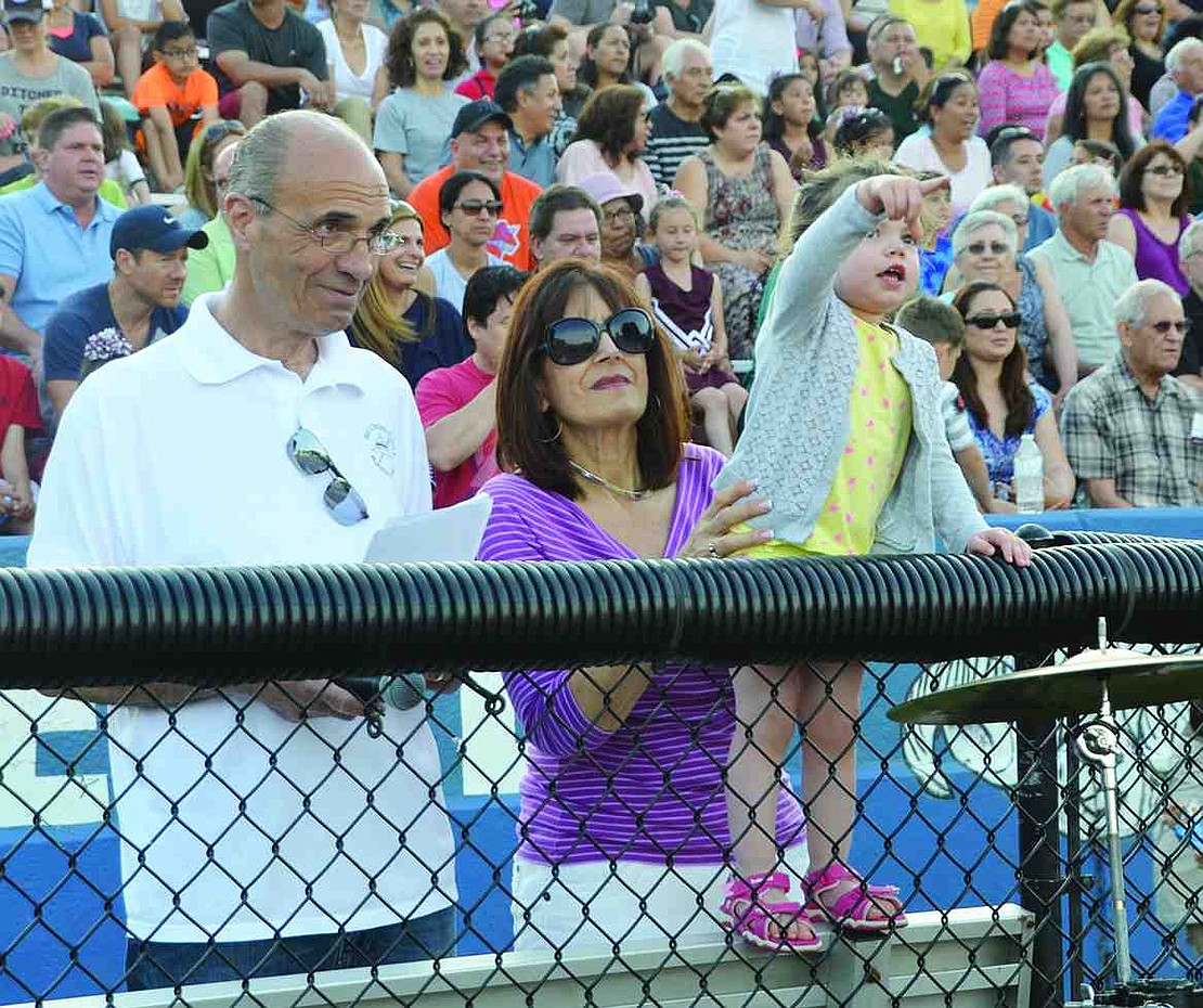 Phil Gasparini, the emcee for Band Night and the business manager for the Port Chester High School Band Parents Association, watches the students perform along with his wife Gaylene and granddaughter Jillian. 