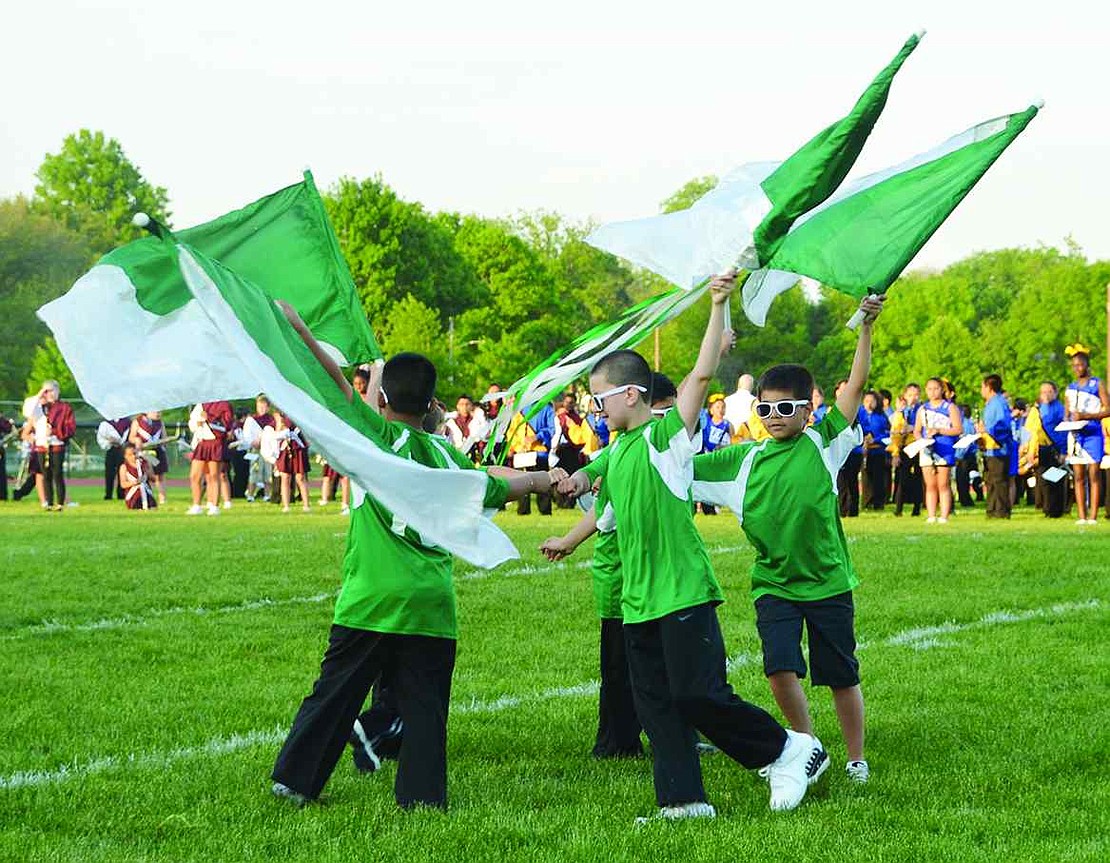 Sunglasses firmly in place, boys from Edison School wear green t-shirts and wave matching flags at the 71st annual Band Night on Tuesday, May 26.