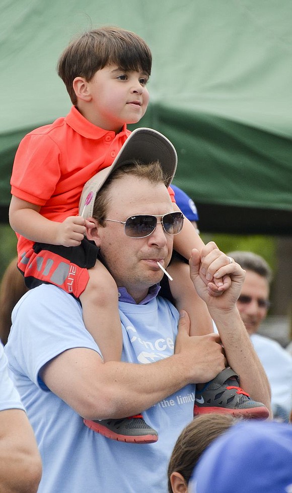 Three-year-old Carter Fishbach of Legendary Circle sits on his father Raphael's shoulders during the opening ceremony. 