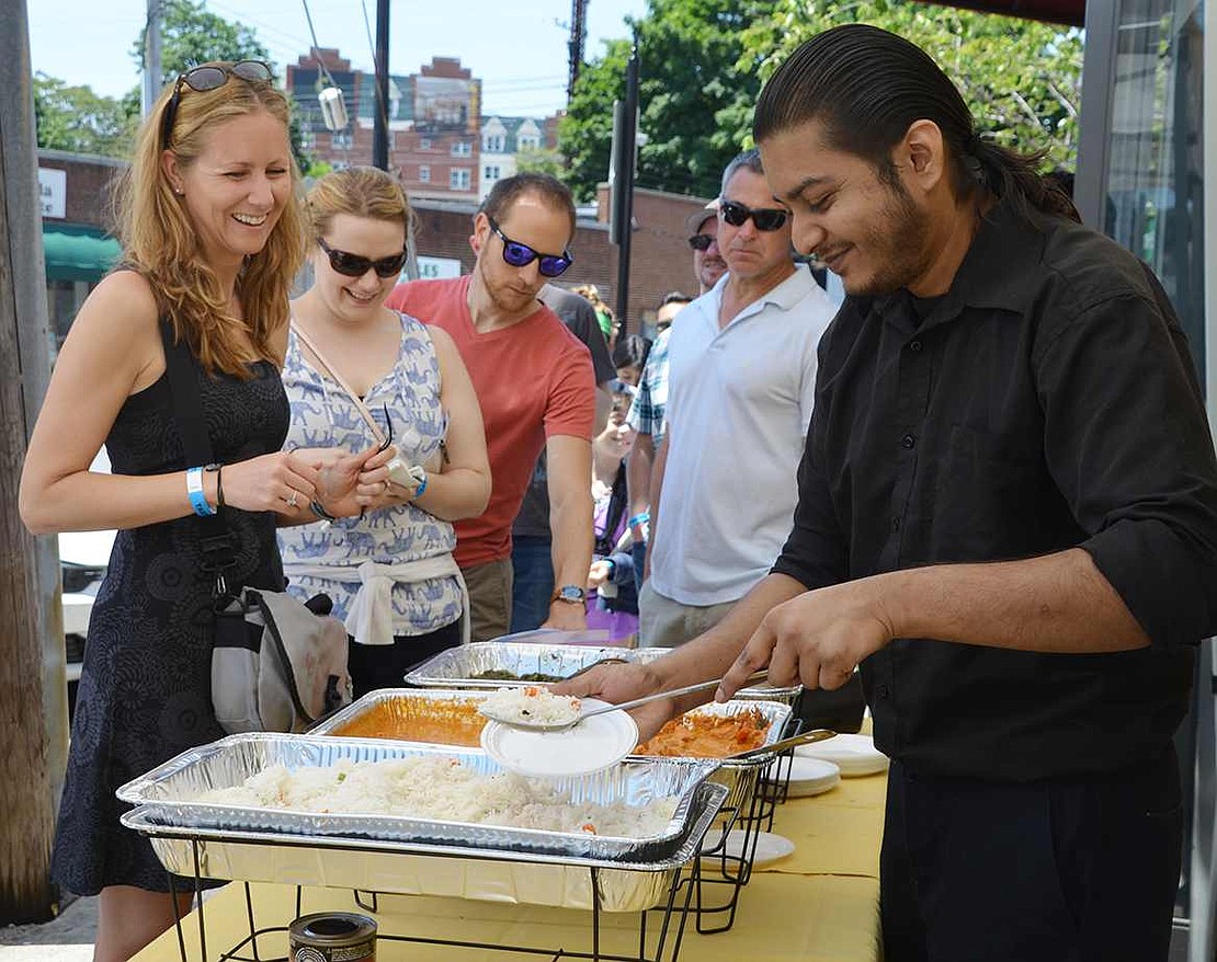  Laura Dopkins of Halstead Avenue waits for Raymond Rodriguez from Tandoori to dish up some Indian food at the Taste of Port Chester on Sunday, June 7. 