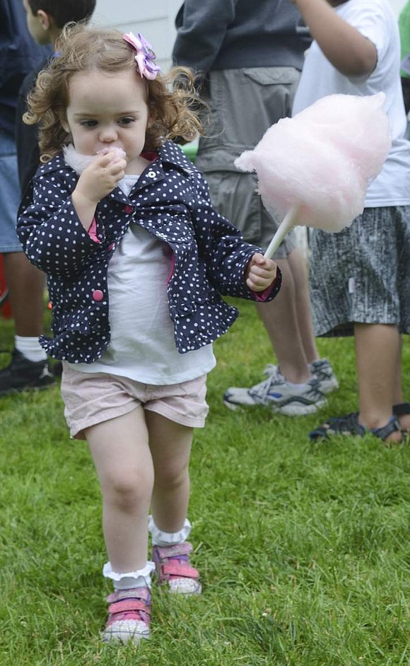 Julia Grady, a Rye Brook 2-year-old, snacks on cotton candy that is bigger than her head. 