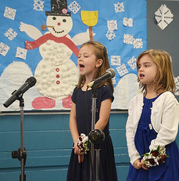 Aline Vandergoten and Carlee Gabriel from Keri Fischer's class address the audience made up of parents, relatives and district administrators. 