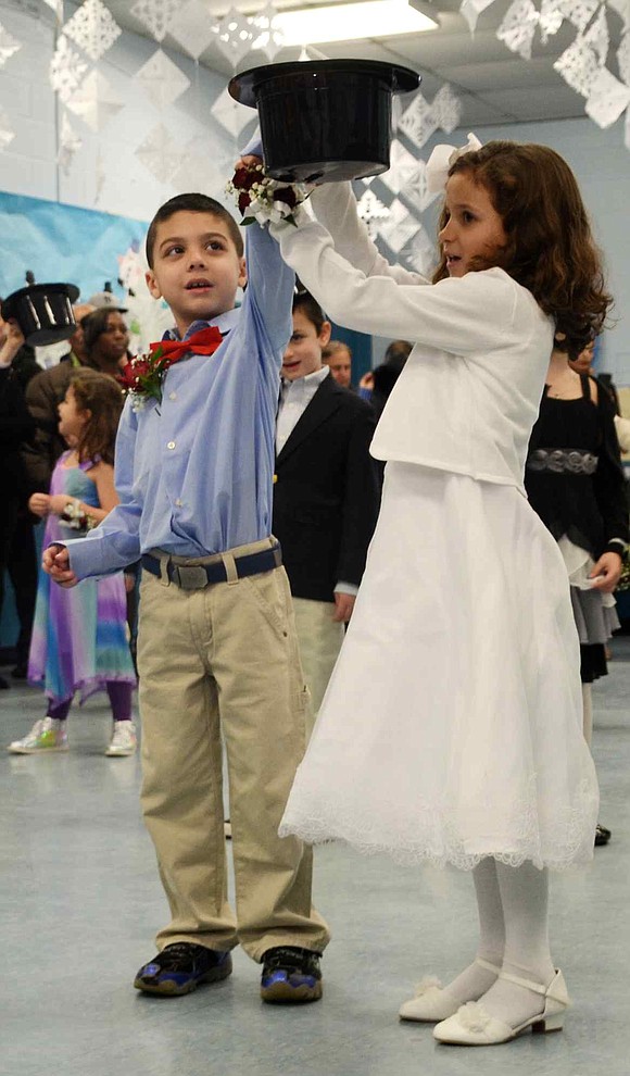 Cassandra Brunetti helps Ray Granda place a top hat on his head while singing "Frosty the Snowman." 