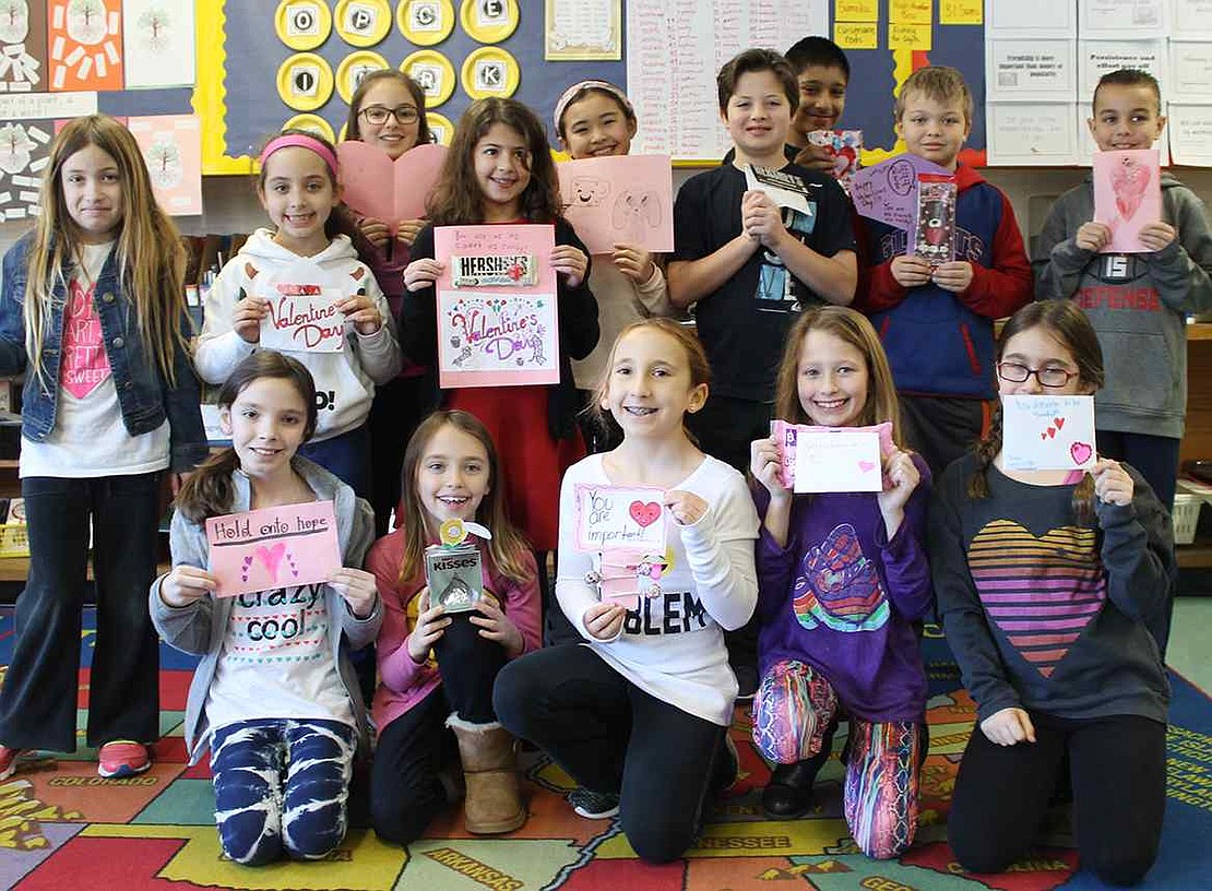  Ridge Street School fourth graders from Laurel DeLuca's class hold up the valentines they made for homeless children. 