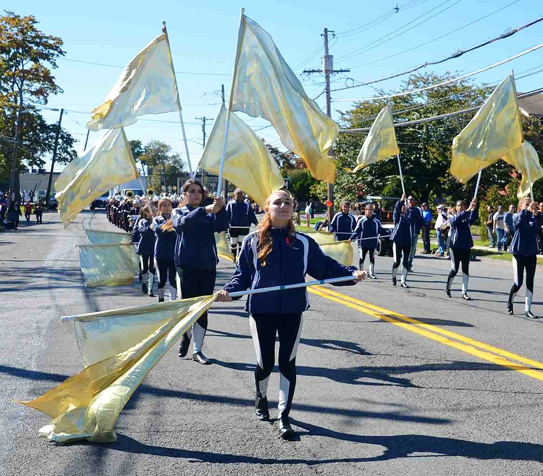 Port Chester High School senior Amanda Vitola twirls a flag along with her fellow students in the marching band's color guard. 