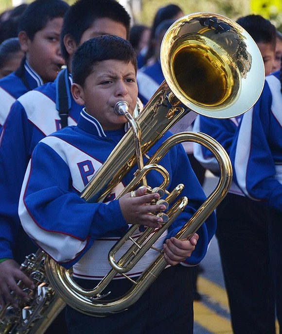 Face scrunched up in concentration, Pedro Quirivum, a Port Chester Middle School 6th grader, plays the tuba.