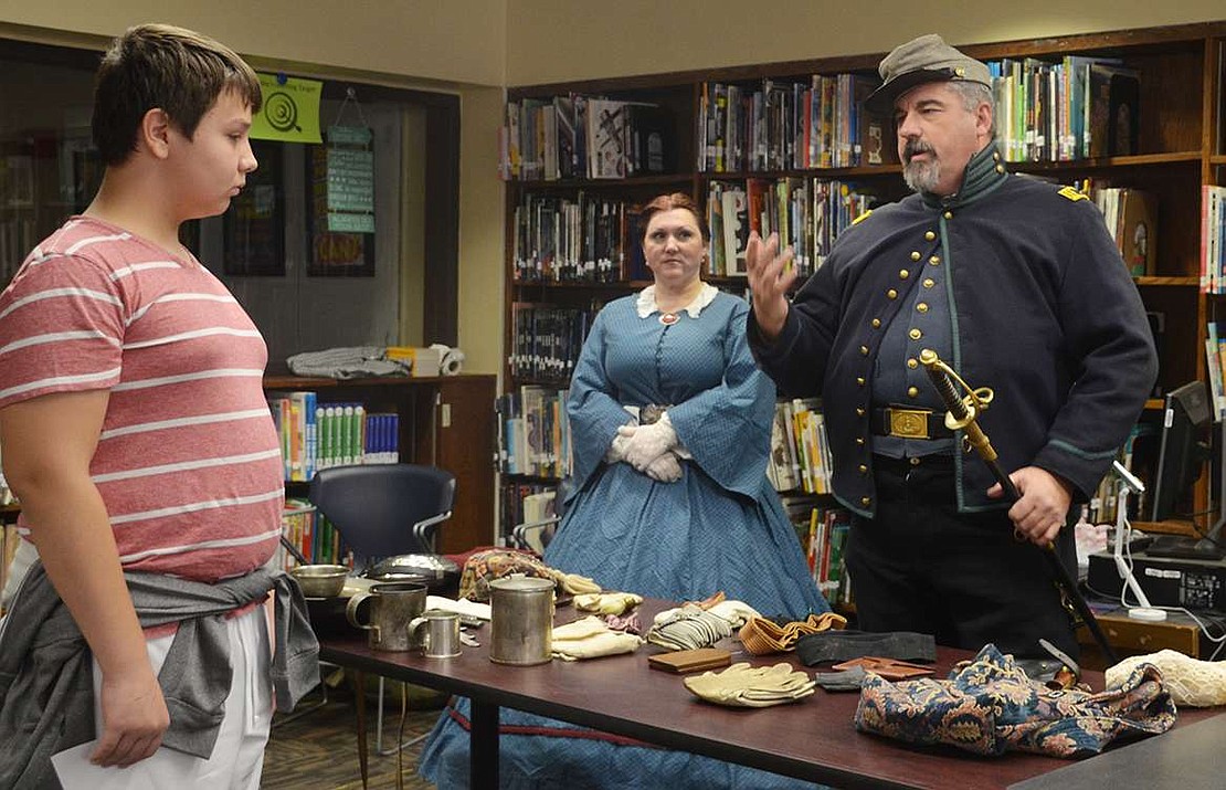  Eighth grader Joseph Campos asks some of the reenactors from the 57th Virginia Infantry Company B some questions after their presentation about setting up camp and fighting battles during the Civil War.