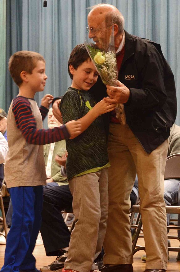  Adam Tomasetti, who served in the U.S. Army, accepts flowers from his grandsons, Colin and Jack Casey. 