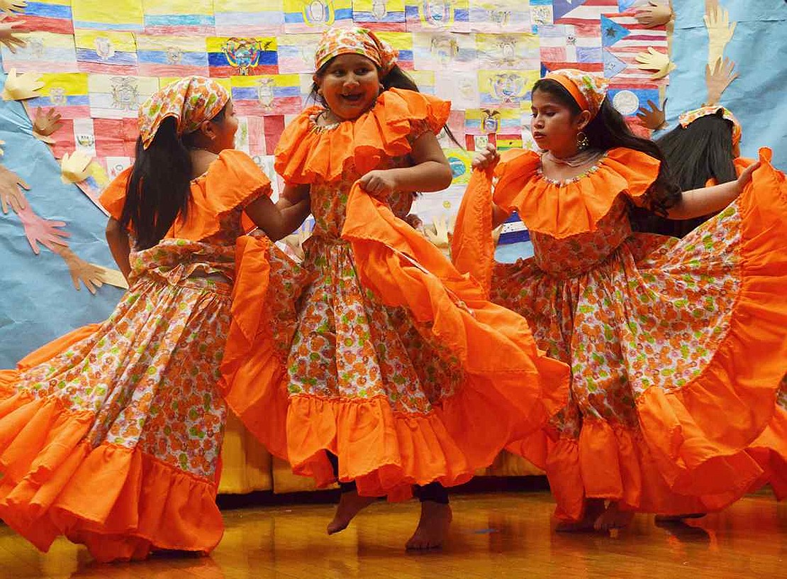 Holding up their bright orange skirts, Jocelyn Lopez and Adriana Galarza twirl around. The community gathered at the school on Friday evening, Nov. 13 for a Hispanic heritage celebration, organized by Thomas A. Edison School's Parent Teacher Organization.  
