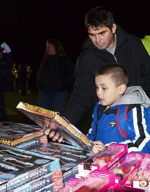  Wilfredo Cardenas and his son Jeremy look at a train set, one of the many toys made available by the Port Chester Recreation Department. The Port Chester boy ultimately picked a keyboard instead. 