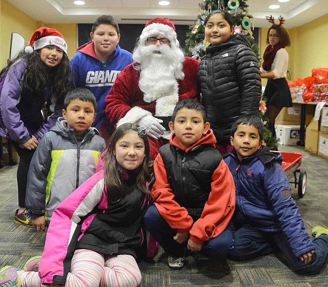  Port Chester children crowd around Santa to get their picture taken with him at Open Door. 