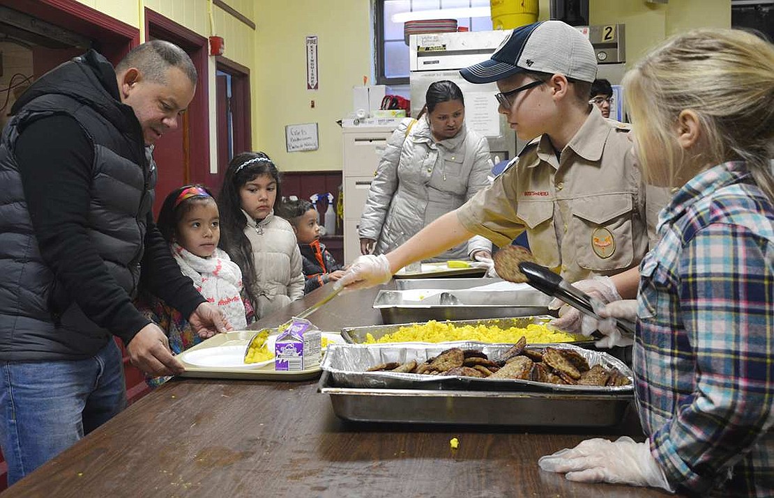  John Fredette from Pack 35 dishes up some scrambled eggs while his sister Tess stands ready to serve the sausage. The Boy Scouts based in Greenwich, Conn. cooked and served breakfast to the many people who showed up on Saturday. 