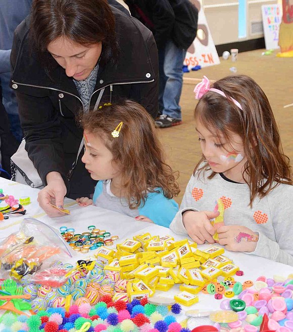 <p class="Picture">Stacy Gonzalez of Greenway Circle helps her daughters Saralina and Gabby pick out prizes to exchange for the tickets they collected at the carnival&rsquo;s various games and activities.</p>