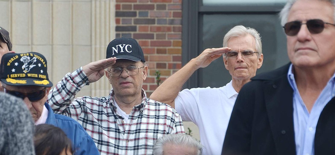  United States Army veterans Carl Mecca, of the 1st Cavalry Division, and Fred De Barros, of the 25th Infantry Division, salute during the playing of "Taps."