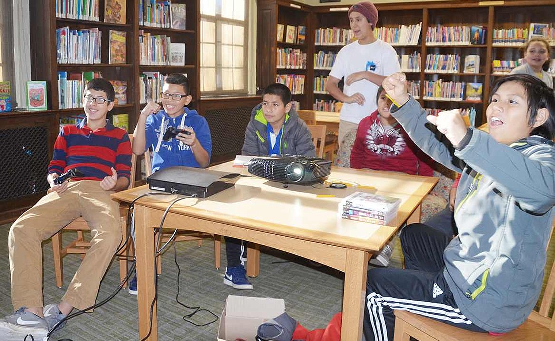  Local teenagers celebrate scoring a goal on the FIFA game on the PlayStation 3.