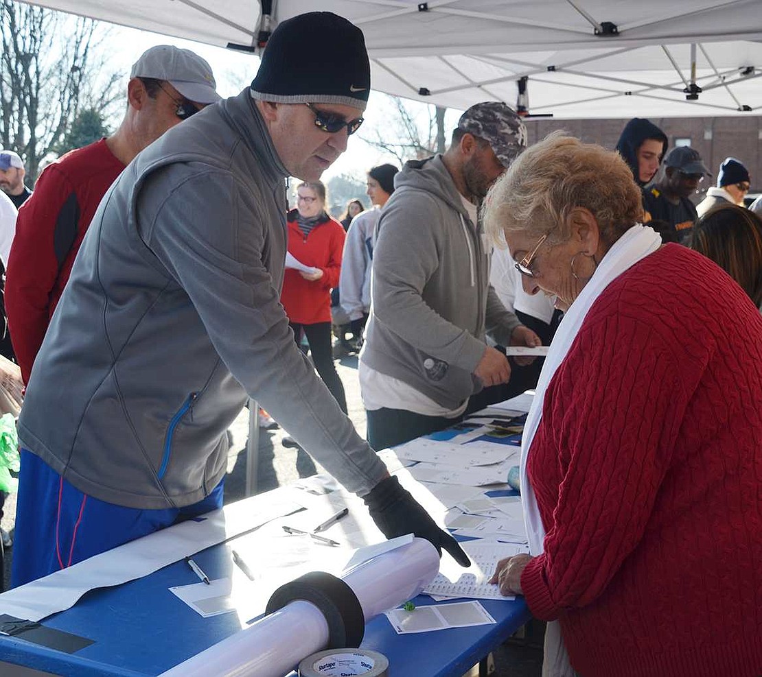  Rosemarie Barone, who chaired the Turkey Trot, registers a runner. 