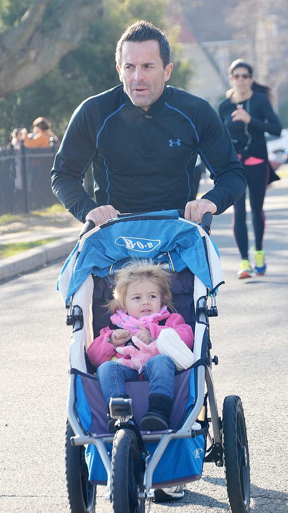  Alfonse Garguilo of Port Chester runs along the course pushing 2-year-old daughter Brooklyn in a stroller. 