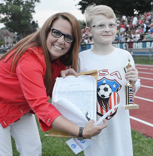 Hope Klein, who organized the Independence Day celebration, stands with Wyatt Feist, a rising third grader at Ridge Street School, holding the replica of the Declaration of Independence he made as his winning contest entry. 