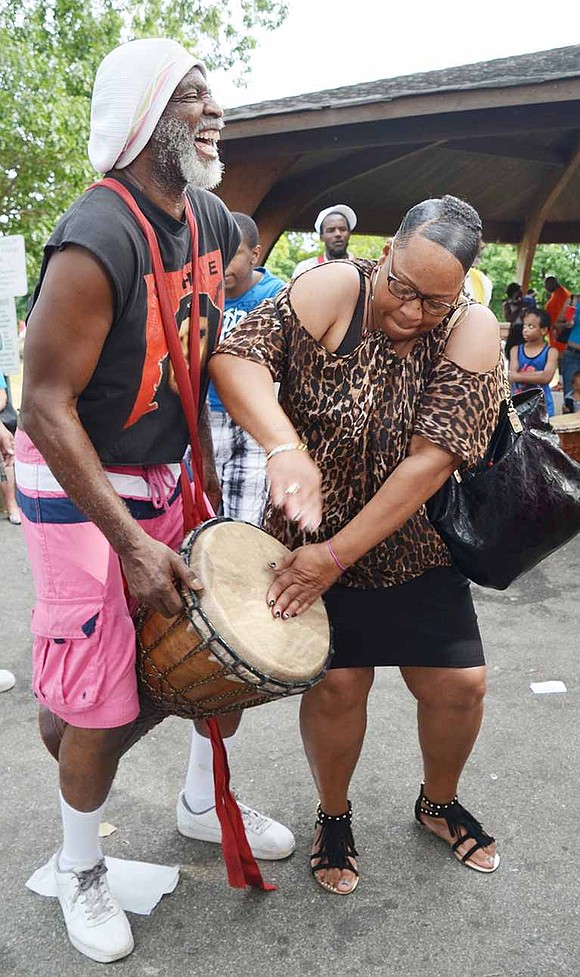 Port Chester resident Danielle Bell bangs on the drum held by Baba Abisha, an elder from the African Healing Circle from Mount Vernon, which entertained Unity Day attendees. 