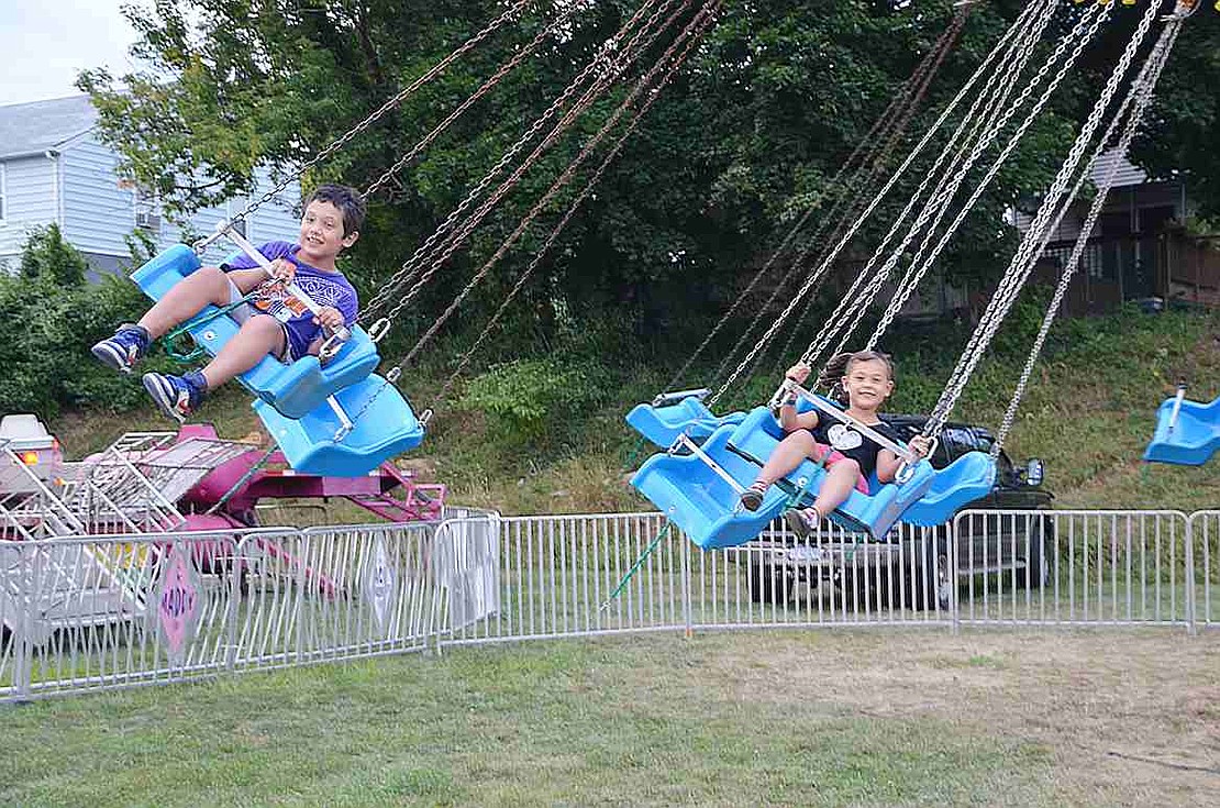 Abril  and Ariel Coyt of Port Chester fly through the air on swings.