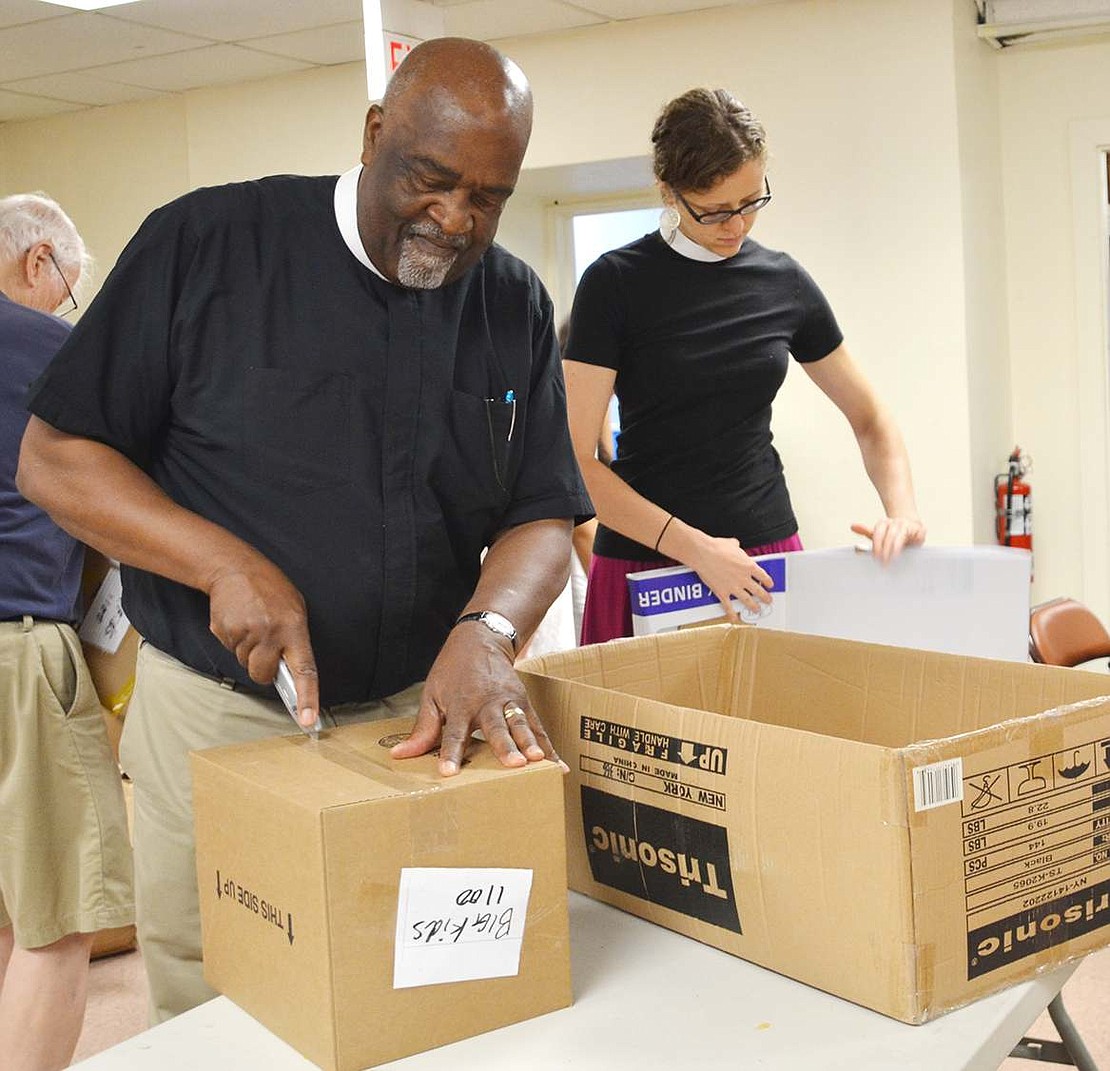  Fr. Hilario Albert from St. Peter's Episcopal Church in Port Chester and Kristin Saylor, a priest associate who joined the Port Chester church this summer, break down boxes that had been full of school supplies. 